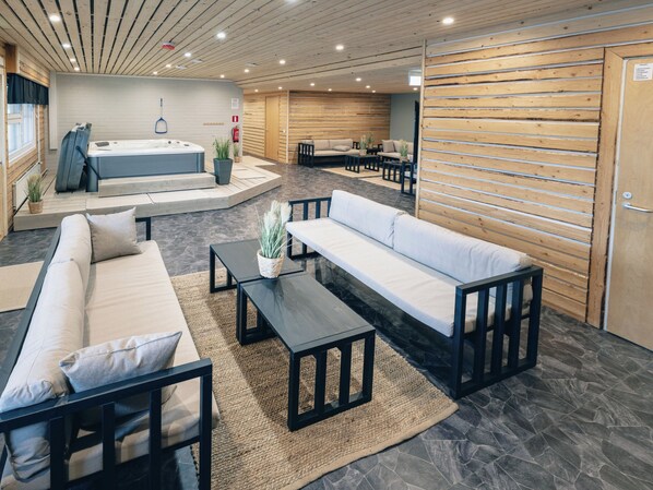 A modern interior with a sofa set, a coffee table, and a hot tub.