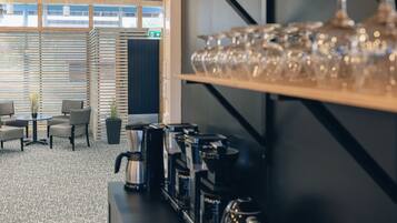 Un espace café moderne doté de plusieurs machines à café et d’un présentoir en verre.