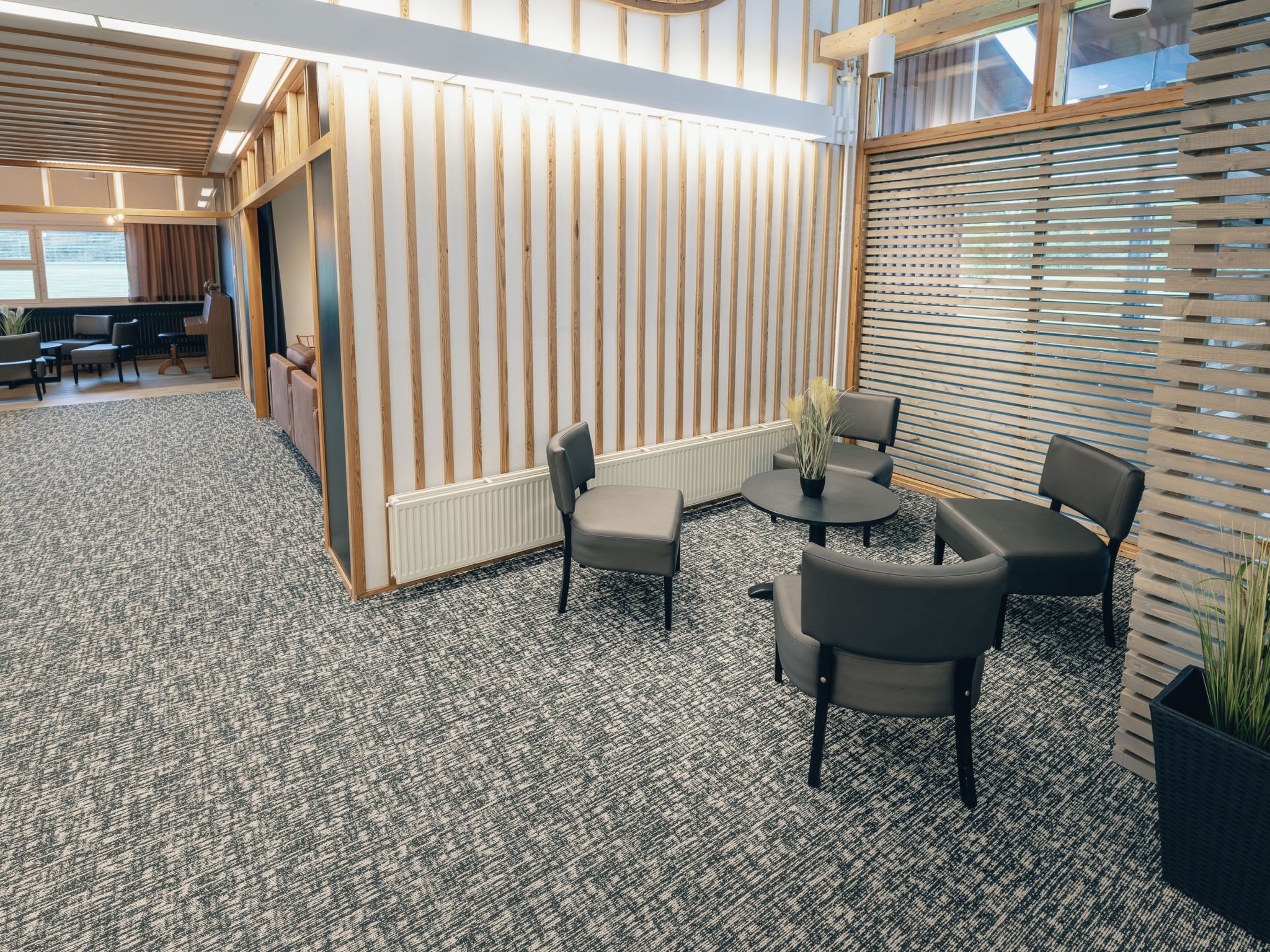A modern interior with a seating area, a reception desk, and a large window.