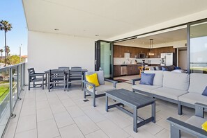 Een moderne buitenruimte met terras, eethoek en keuken.