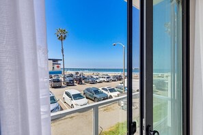 Vista de un estacionamiento con autos y una playa al fondo.