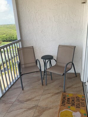 Enjoy a peaceful retreat with a balcony featuring a table and chairs, overlooking a serene green landscape.