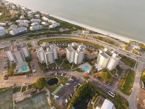 Residents enjoy scenic views of the ocean from this high-rise complex, featuring a central courtyard with a swimming pool and parking spaces.