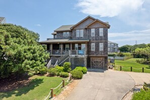 A two-story wooden house with a covered porch and a garage.