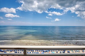 Une plage avec des parasols et des gens.