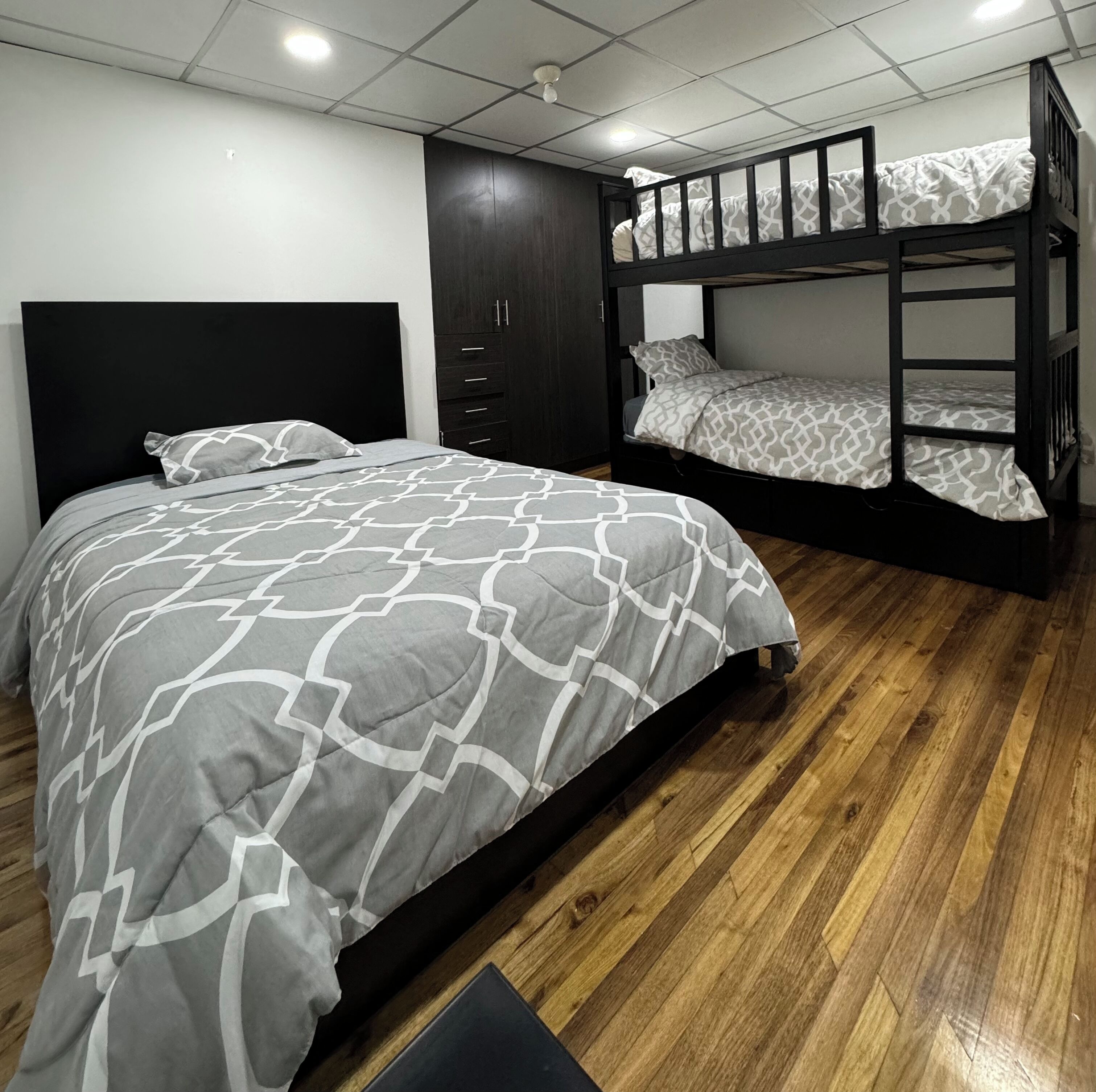 A bedroom with a large bed, a wardrobe, and a bunk bed.