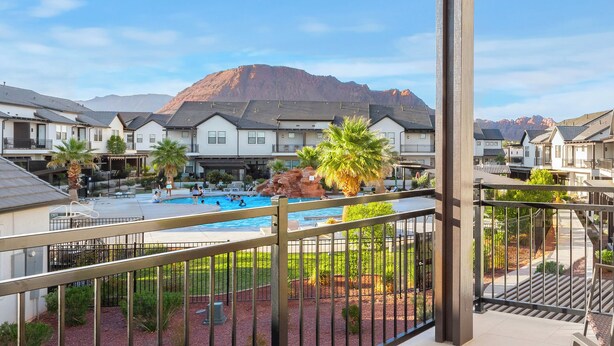 Zona residenziale con piscina, palme e una montagna sullo sfondo.