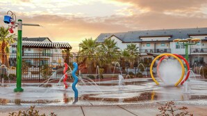 Un parco acquatico con una fontana, una scultura a spirale e un edificio sullo sfondo.