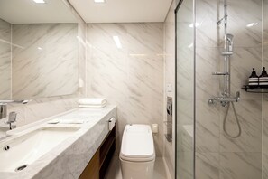 A modern bathroom with a marble vanity, a toilet, and a glass-enclosed shower area. - Zizel Signity (Seoul)