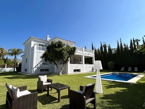 A two-story house with a pool, outdoor furniture, and a well-maintained lawn. - Villa Maisa Luxury Marbella by Málaga Planners (Marbella)
