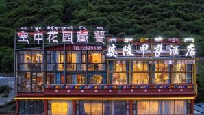 A multi-story building with illuminated signage, a visible telephone number, and a balcony with colorful decorations. - MAERkANG PO LING JIA SA HOTEL (Barkam)