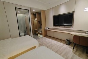 A modern hotel room with a large bed, a desk, a TV, and a bathroom with a glass door. - MAERkANG PO LING JIA SA HOTEL (Barkam)