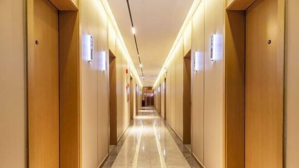 A long, well-lit hallway with wooden doors and a shiny floor, leading to a distant exit. - MAERkANG PO LING JIA SA HOTEL (Barkam)