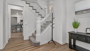 Una escalera con barandillas blancas y piso oscuro.
