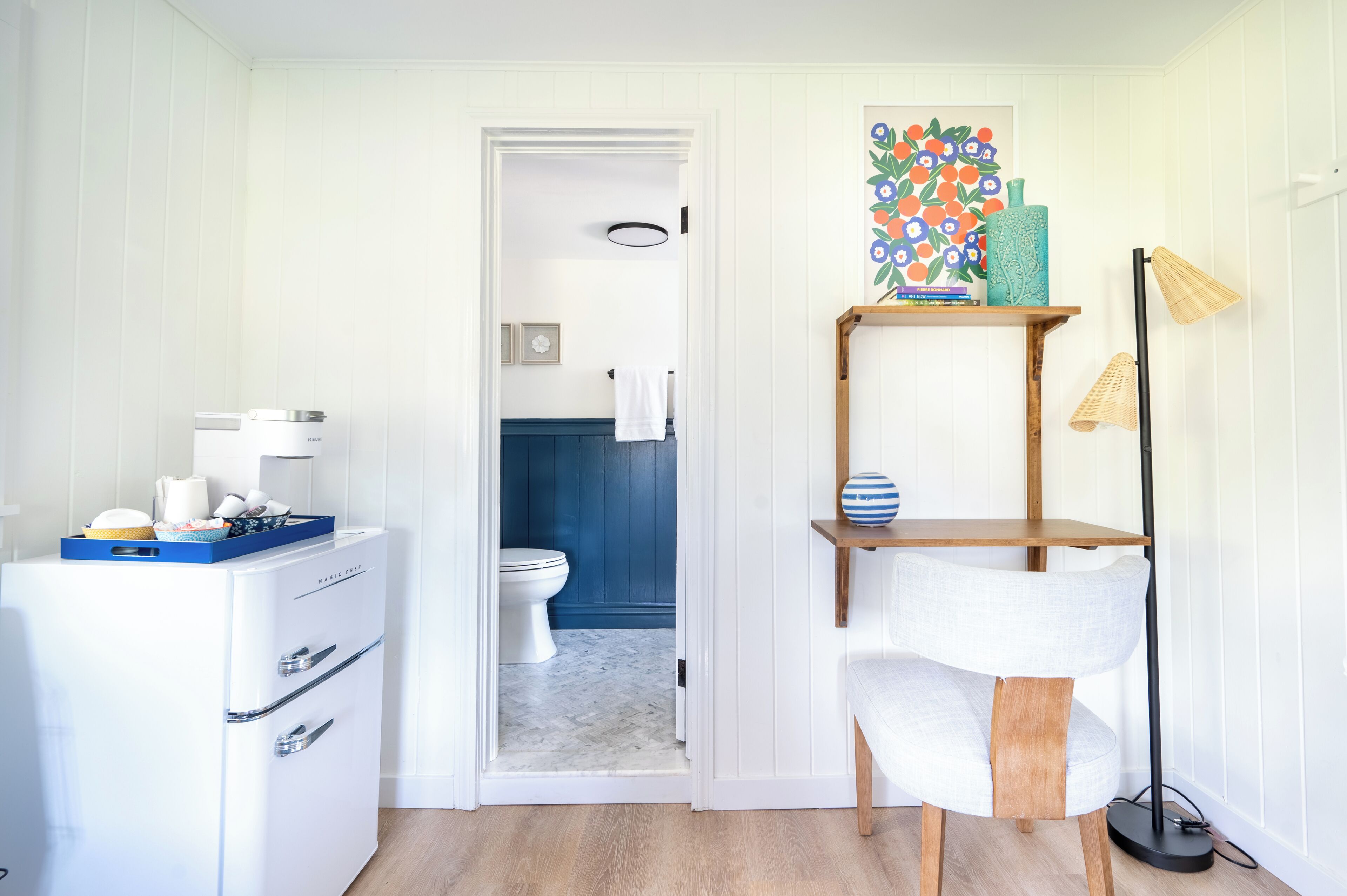 Een kleine badkamer met een wit wastafel, een wit toilet en een blauwe douchecabine.