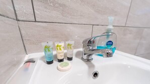 A bathroom sink with three toiletries: a shower gel, a body lotion, and a bar of soap. - Stunning 1-Bed Studio in Birmingham available (Birmingham)