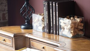 A wooden desk with a lamp, books, and a container of corks. - Downtown Cozy Castlerock Suite (Wenatchee)
