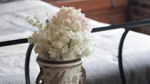 A glass table with a white vase with floral patterns, a book titled "Wenatchee," and a cushion in the background. - Downtown Cozy Castlerock Suite (Wenatchee)