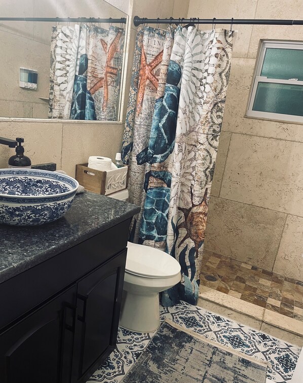 A bathroom with a toilet, sink, and shower curtain with a nautical theme. - Bradenton Cozy Haven - Escape to our charming 3-bed, 2-bath Bradenton retreat! (Bradenton)