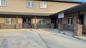 A building with a beige exterior, a front entrance with glass doors, and a sign reading "BODY & SOUL Wellness." - Cozy One Bedroom Apartment in Sheridan (Sheridan)