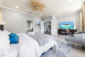 Ein Schlafzimmer mit einem Bett, einem Fernseher und einem Sofa.