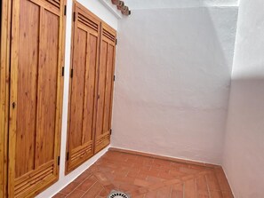 Un coin de pièce avec des portes en bois et un sol carrelé.