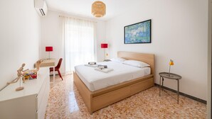 Une chambre d’hôtel moderne, équipée d’un lit, d’un bureau, d’une chaise et d’une œuvre d’art au mur.