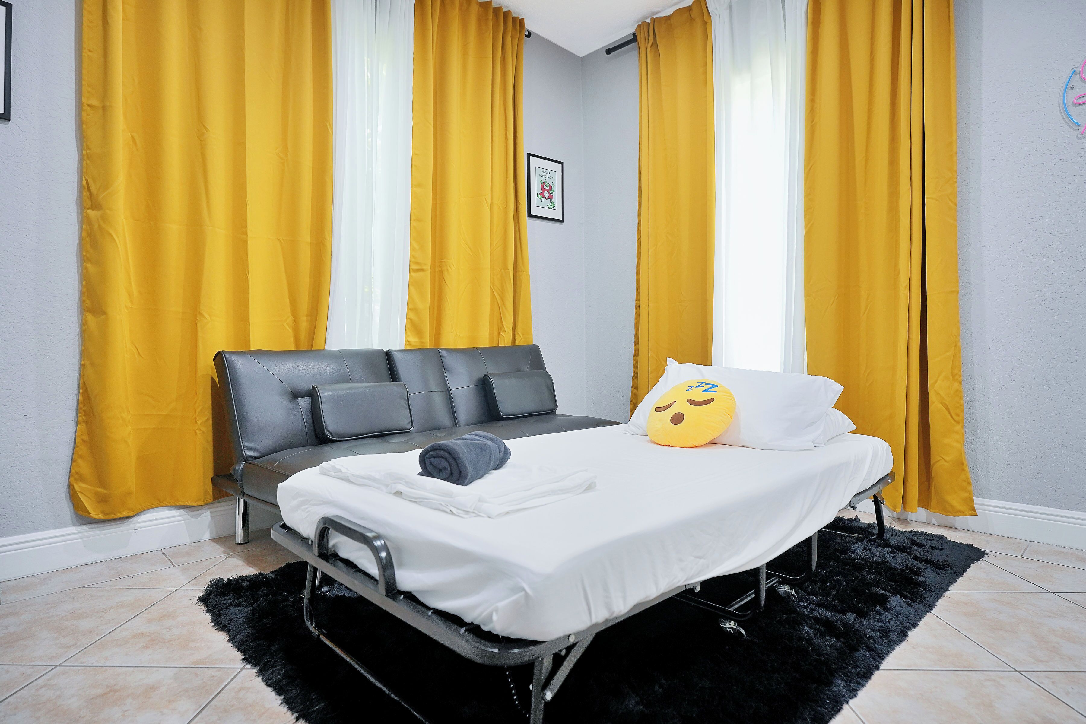 Ein Schlafzimmer mit einem Bett, einer Couch und einem schwarzen, flauschigen Teppich.