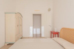 A bedroom with a bed, a wardrobe, a nightstand, and a door leading to another room. - Elegant Residence Ea Bianca 1 Bedroom Sleeps 4 Child num0607 (Sardegna)