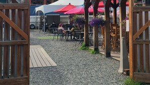 A sign for a historic Fairview Inn beer garden with outdoor seating and umbrellas. - Fairview Inn (Talkeetna)