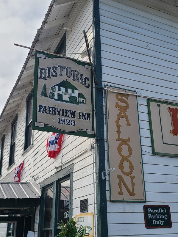 A historic building with a sign for the Fairview Inn, established in 1923, and a sign indicating parallel parking only.