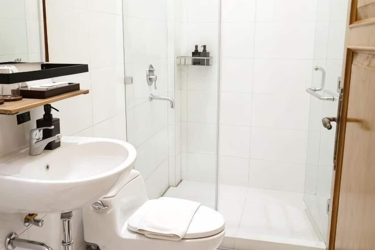 Ein Badezimmer mit weißem Waschbecken, WC und Duschkabine.