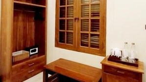 A room with a wooden wardrobe, a wooden cabinet, a wooden bench, and a window with wooden shutters. - Tirtodipuran Hotel  (Yogyakarta)