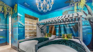 A room with two beds, a wooden wall, a mural, and a chandelier.