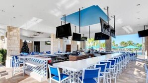 A bar area with white bar stools and a central bar counter.