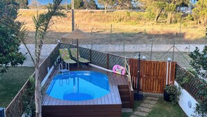 A backyard with a wooden deck, a swimming pool, and a fenced area with a view of the sea. - THE CORNER OF THE RIA (Torreira)