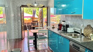 A modern kitchen with blue cabinets, a built-in dishwasher, and a dining area with a table and chairs. - THE CORNER OF THE RIA (Torreira)