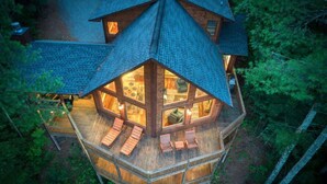 A wooden cabin with a large deck, multiple windows, and a cozy interior. - Pineview Escape - Hot tub, arcade & mountain views (Blue Ridge Mountains)