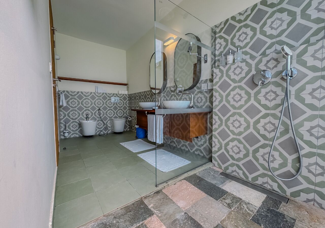 A bathroom with a shower, a sink, and a toilet.