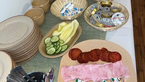A buffet table with various food items, including sliced cucumbers, bananas, and different types of meat and cheese. - Győr (Gyor)