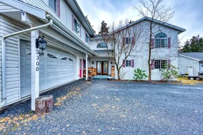 A two-story house with a garage, a front porch, and a driveway. - 7BR Hot Tub Lodge • Sleeps 14 • Kodiak (Kodiak)