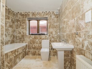 Baño con inodoro, lavamanos y ventana.