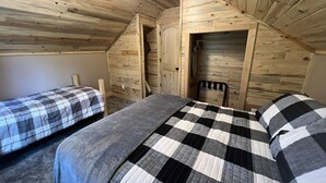 A cozy attic bedroom with two beds, wooden walls, and a sloped ceiling. - 20 min to Yellowstone, Loft (Island Park)