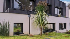 A modern two-story house with large windows, a flat roof, and a well-maintained lawn. - L'Appart'Mer by Interhome (Plérin)