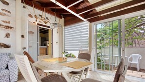 Comedor con una mesa de madera, sillas y vistas al exterior.
