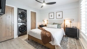 A bedroom with a bed, a ceiling fan, a washing machine, and a nightstand with a lamp. - Designer Ski-In / Ski-Out Condominium At Brian Heads Copper Chase (Brian Head)