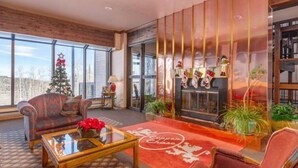 A cozy living room with a fireplace, large windows, and a Christmas tree. - Designer Ski-In / Ski-Out Condominium At Brian Heads Copper Chase (Brian Head)