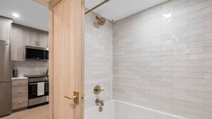 Un baño moderno con bañera, ducha e inodoro.