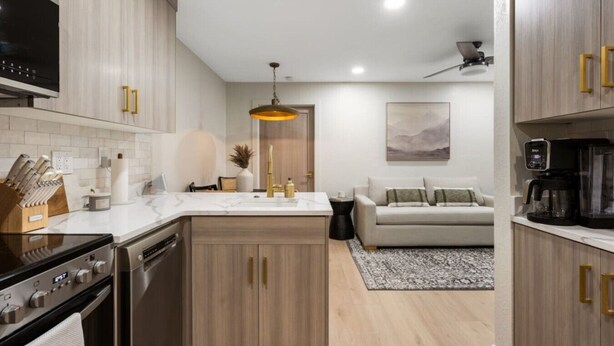 A modern kitchen with a central island, built-in oven, and a coffee maker on the countertop. - Designer Ski-In / Ski-Out Condominium at the top of Brian Heads Navajo Lift (Brian Head)