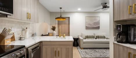 A modern kitchen with a central island, built-in oven, and a coffee maker on the countertop.